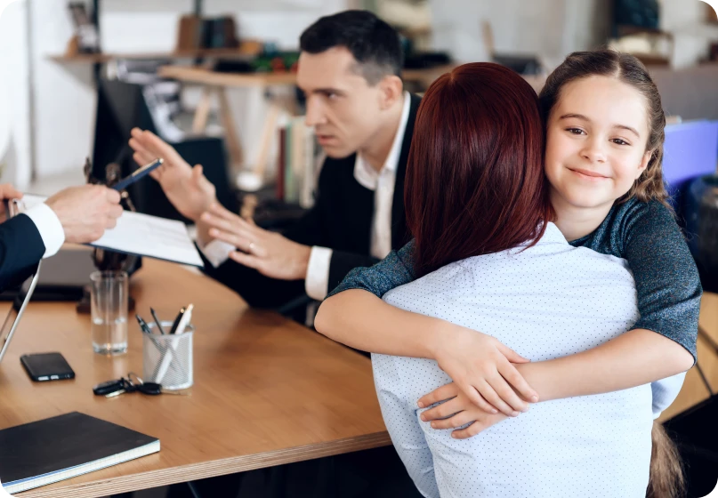 Emotional moment as a child embraces her mother in a meeting with a lawyer