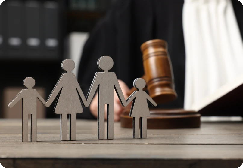 Wooden family figures next to gavel illustrating legal action for non-compliance with court orders.