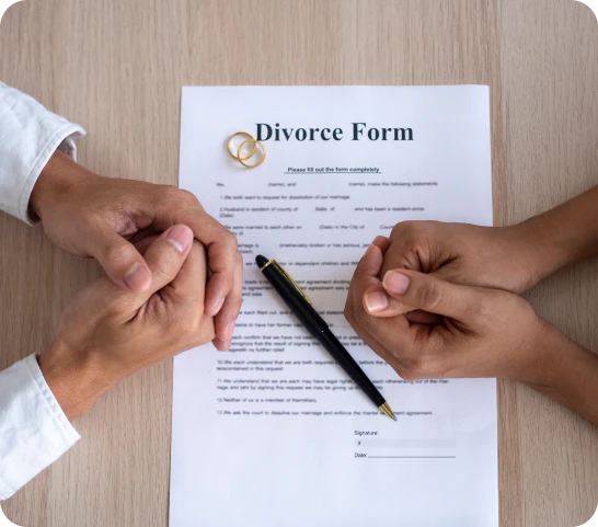 Divorce forms on a table with a couple’s hands, representing family law services in Scarborough.