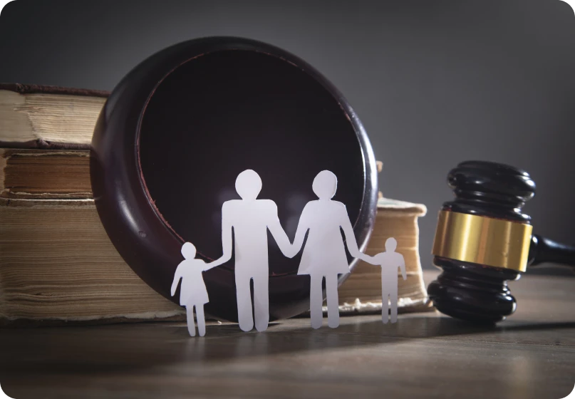 Wooden family figures with legal books and gavel representing collaborative family law and divorce proceedings.